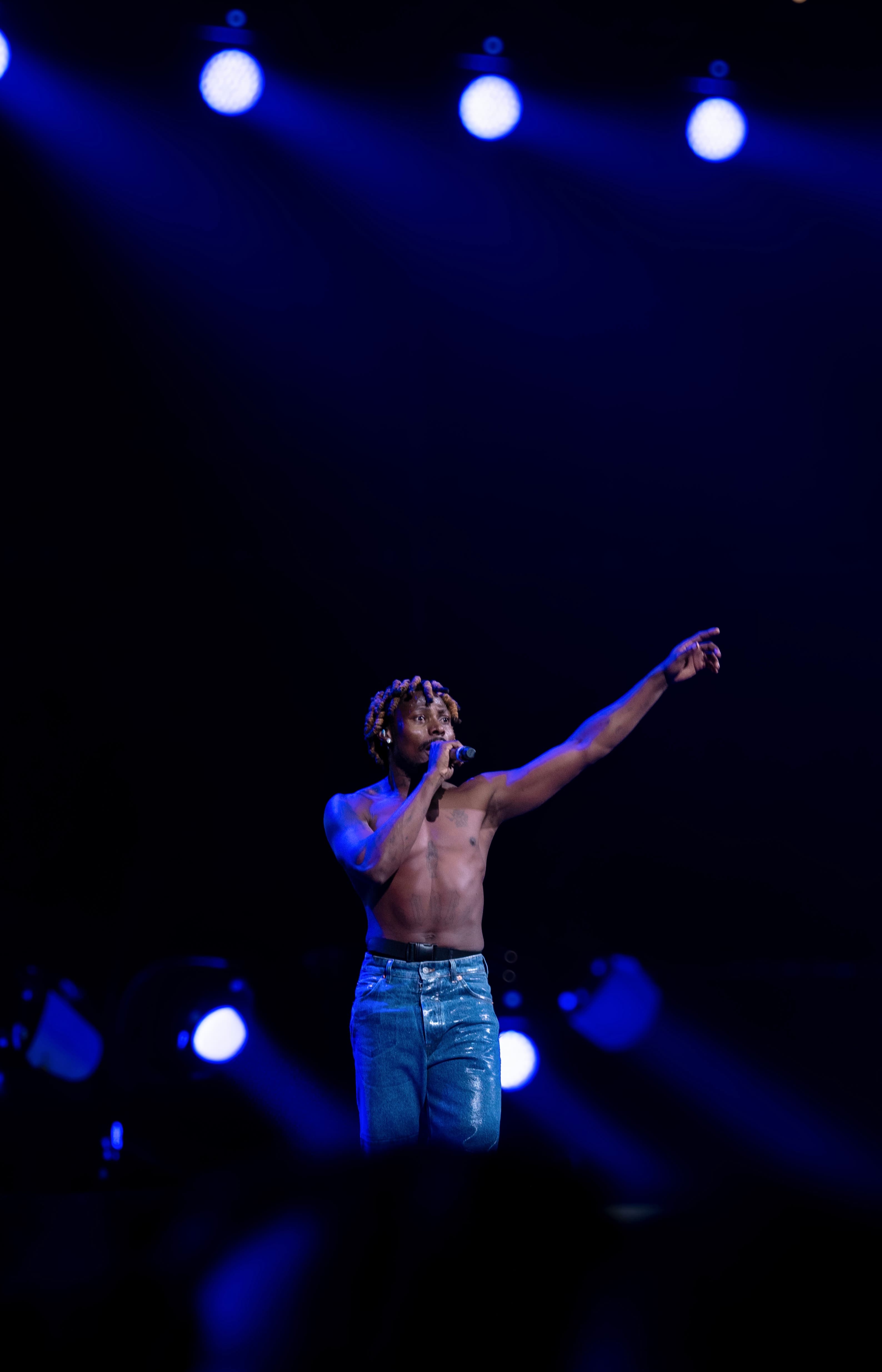 Concert performance, blue stage lights, performer with microphone