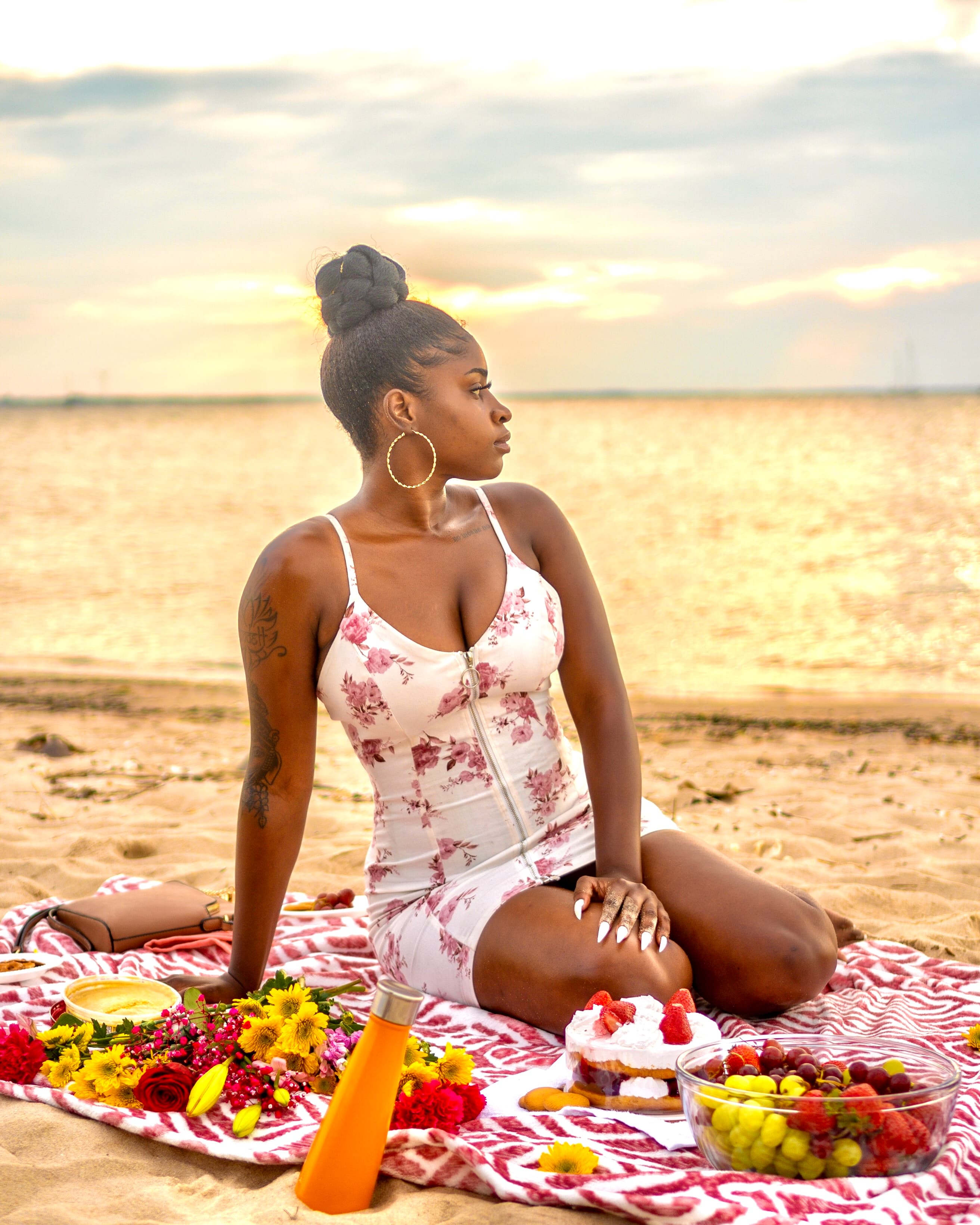 Lifestyle, woman in floral swimsuit at beach sunset picnic