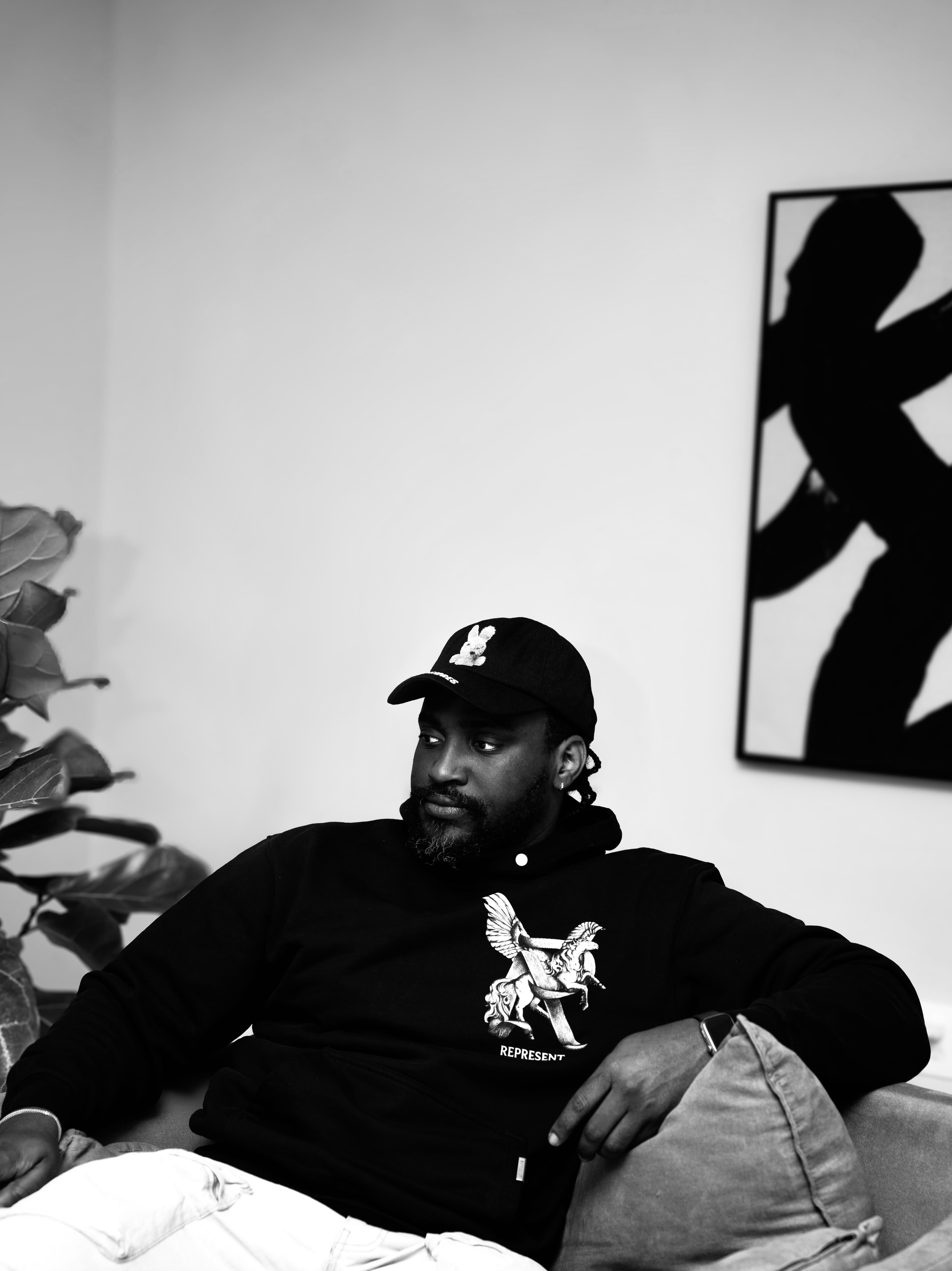 Lifestyle monochrome, man relaxed indoors, art on wall